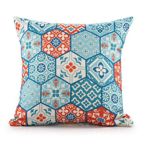 A square throw pillow with a blue, red, and white hexagonal patchwork pattern on a white background.