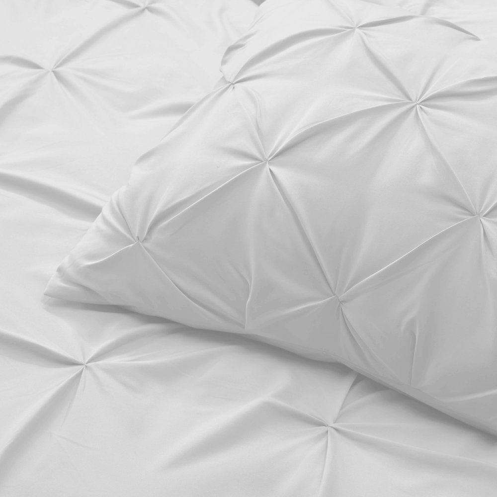Close-up of a white microfiber comforter with a pintuck design, showing the texture and detail of the fabric.