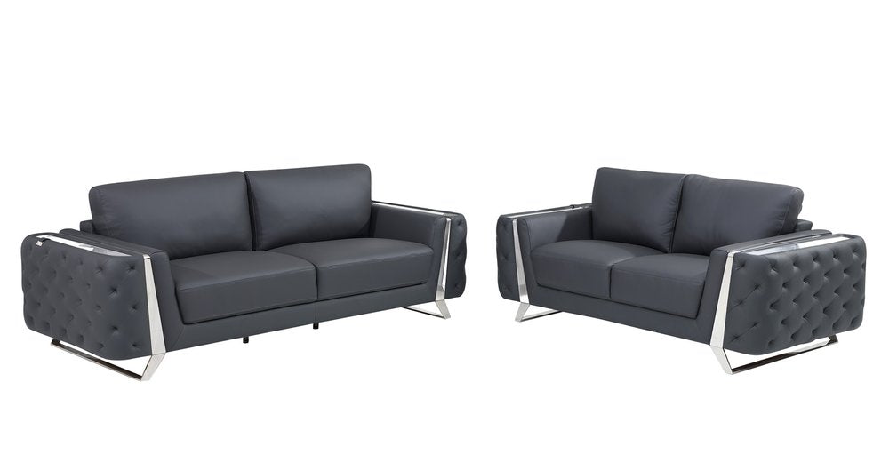 Two dark gray Italian leather sofas with tufted arms and chrome legs on a white background.