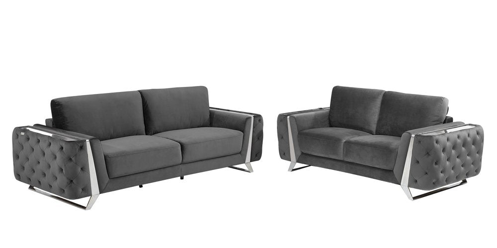 Two dark gray velvet sofas with tufted arms and chrome accents on a white background.