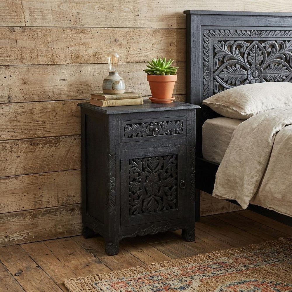 30" Black Solid Wood Distressed One Drawer Nightstand styled in a furnished interior with a tan wall on a dark wood floor.