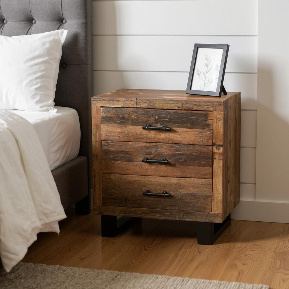 30" Dark Brown Solid Wood Distressed Three Drawer Nightstand styled in a furnished interior with an off-white wall on a dark wood floor.