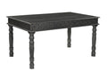Black solid wood dining table with carved apron and turned legs on a white background.
