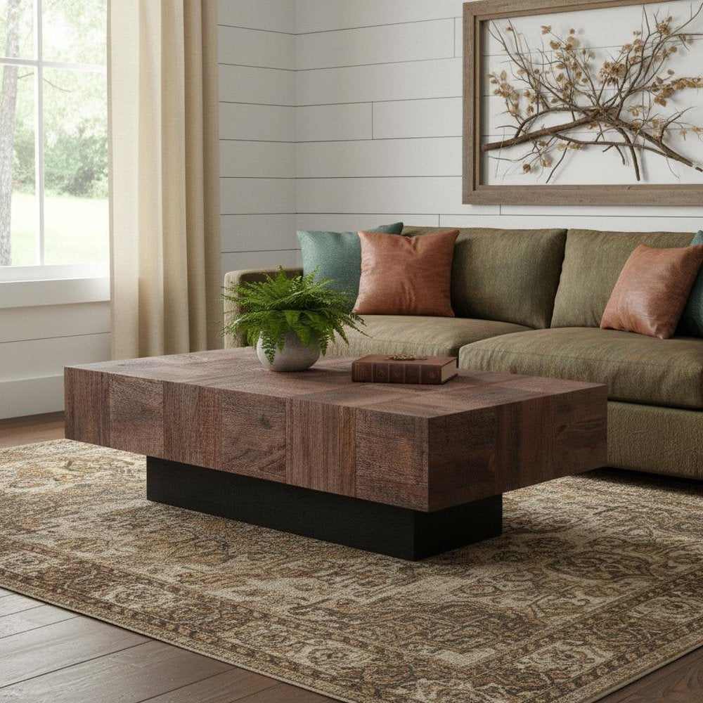 59" Dark Brown and Black Solid Wood Block Coffee Table styled in a furnished interior with a light gray wall on a dark wood floor.