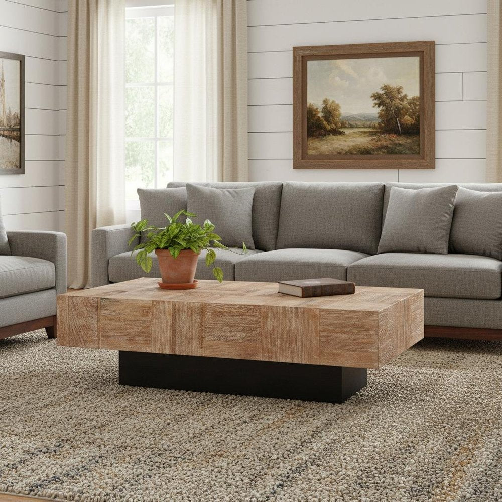 59" Natural and Black Solid Wood Block Coffee Table styled in a furnished interior with a light gray wall on a wood floor.