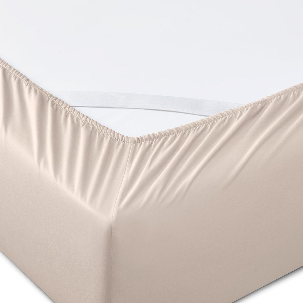 Close-up of a blush tencel lyocell fitted sheet with elastic band on a white background.