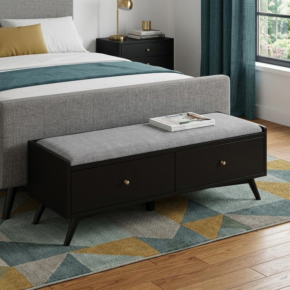 59" Gray and Black Fabric Upholstered Storage Bench with Drawers styled in a furnished interior with a gray wall on a charcoal floor.