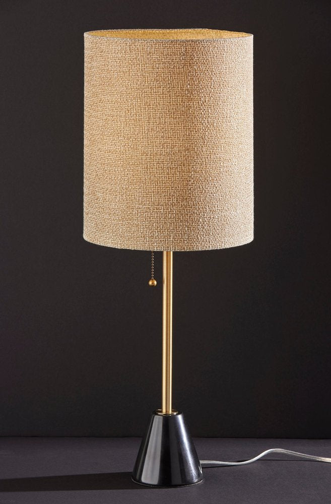 28" Black and Gold Marble and Metal Table Lamp With Beige Drum Shade photographed against a dark studio background in beige.