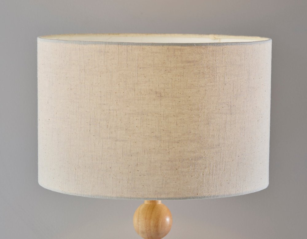 28" Brown Solid Wood Candlestick Table Lamp With Off White Drum Shade close-up highlighting the off-white wood surface.