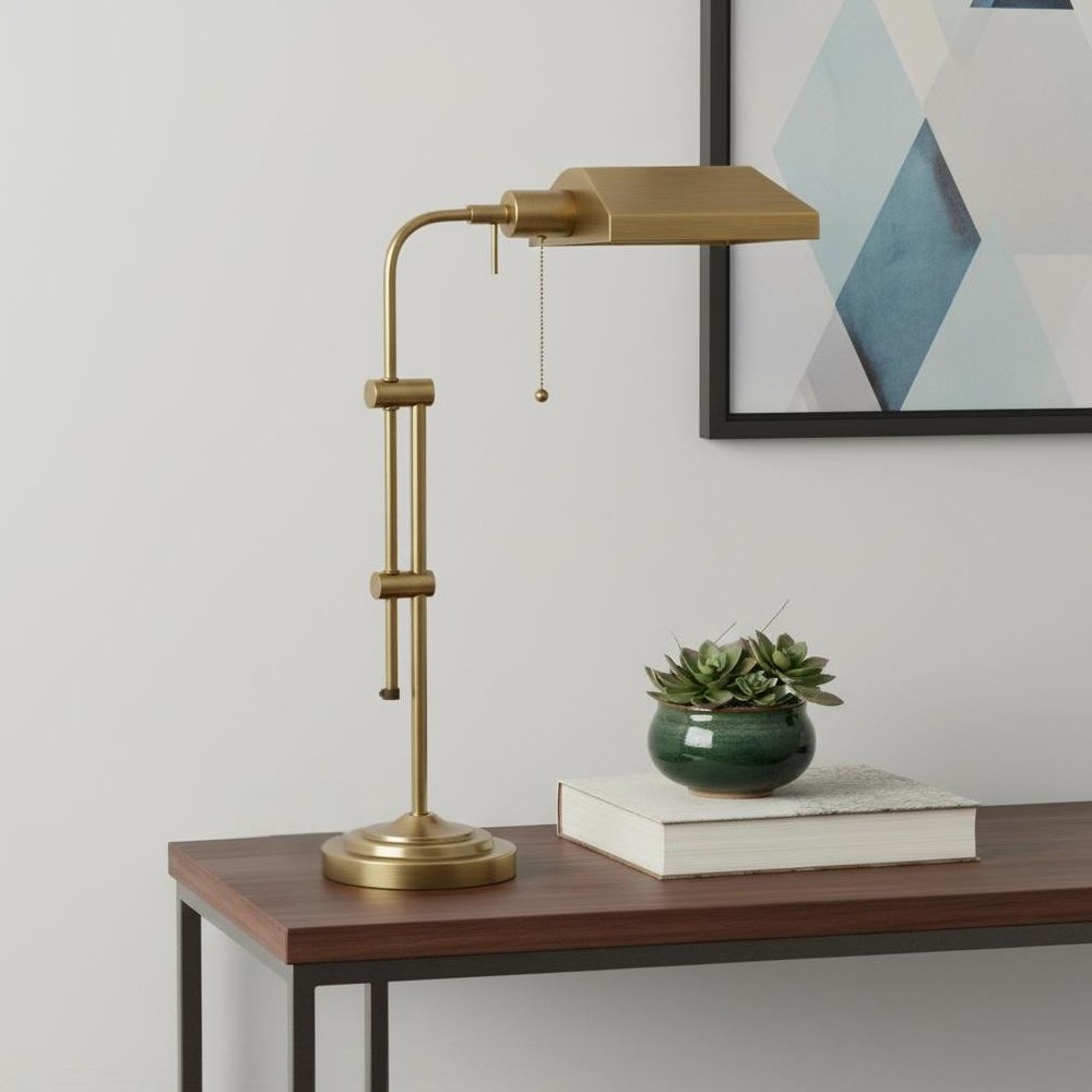 26" Bronze Metal Adjustable Table Lamp With Antiqued Brass Rectangular Shade displayed on a tabletop in a furnished interior against an off-white wall.