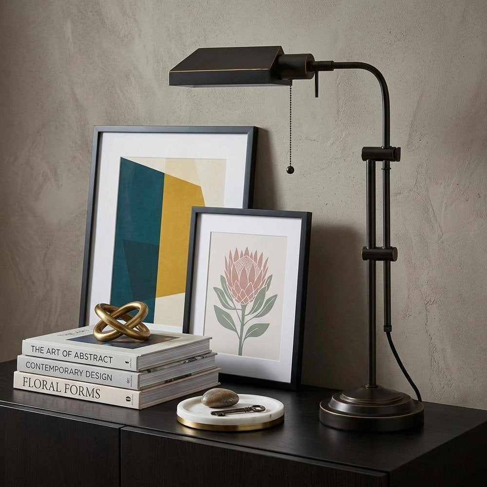 26" Bronze Metal Adjustable Table Lamp With Bronze Rectangular Shade displayed on a tabletop in a furnished interior against a tan wall.