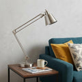 27" Nickel Metal Desk Table Lamp With Nickel Cone Shade displayed on a tabletop in a furnished interior against an off-white wall in silver metal.