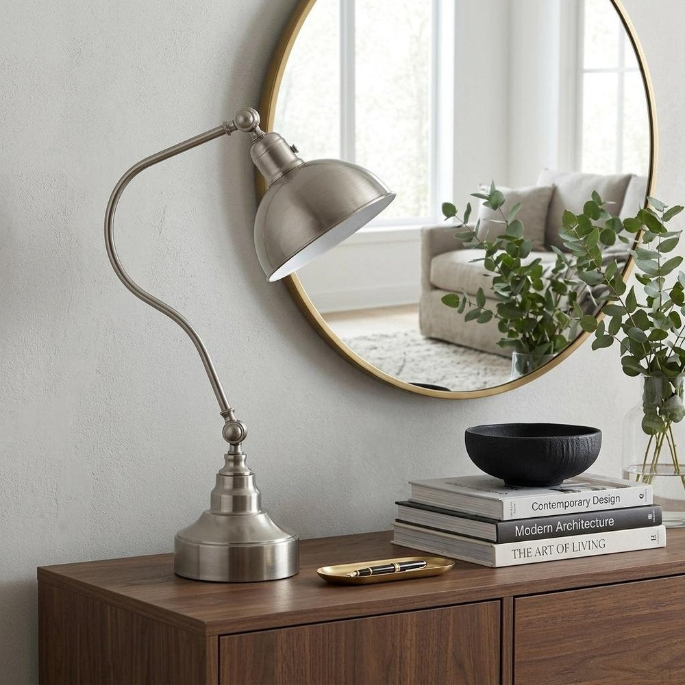 25" Nickel Metal Lantern Desk Table Lamp With Nickel Dome Shade displayed on a dark wood tabletop in a furnished interior against a light gray wall in silver metal.
