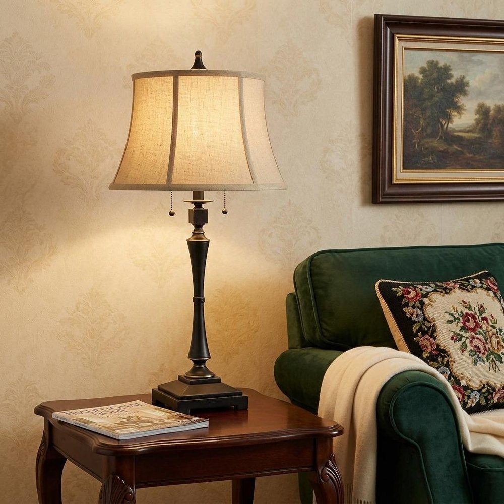 31" Black Metal Two Light Candlestick Table Lamp With Beige Empire Shade displayed on a tabletop in a furnished interior against a cream wall.