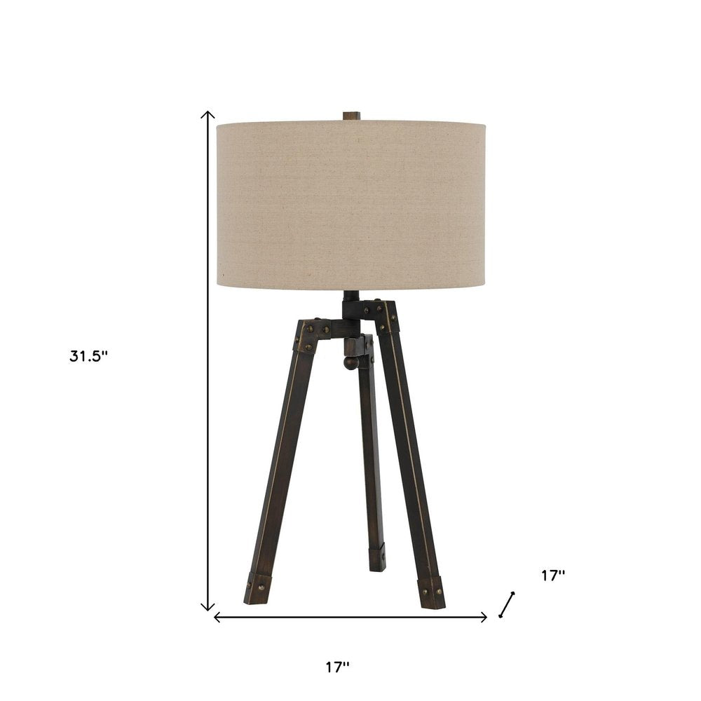 32" Charcoal Metal Tripod Table Lamp With Tan Drum Shade. Table lamp isolated on a plain white background, finished in charcoal metal.