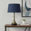 30" Black Metal Urn Table Lamp With Navy Blue Empire Shade displayed on a tabletop in a furnished interior against a light gray wall.