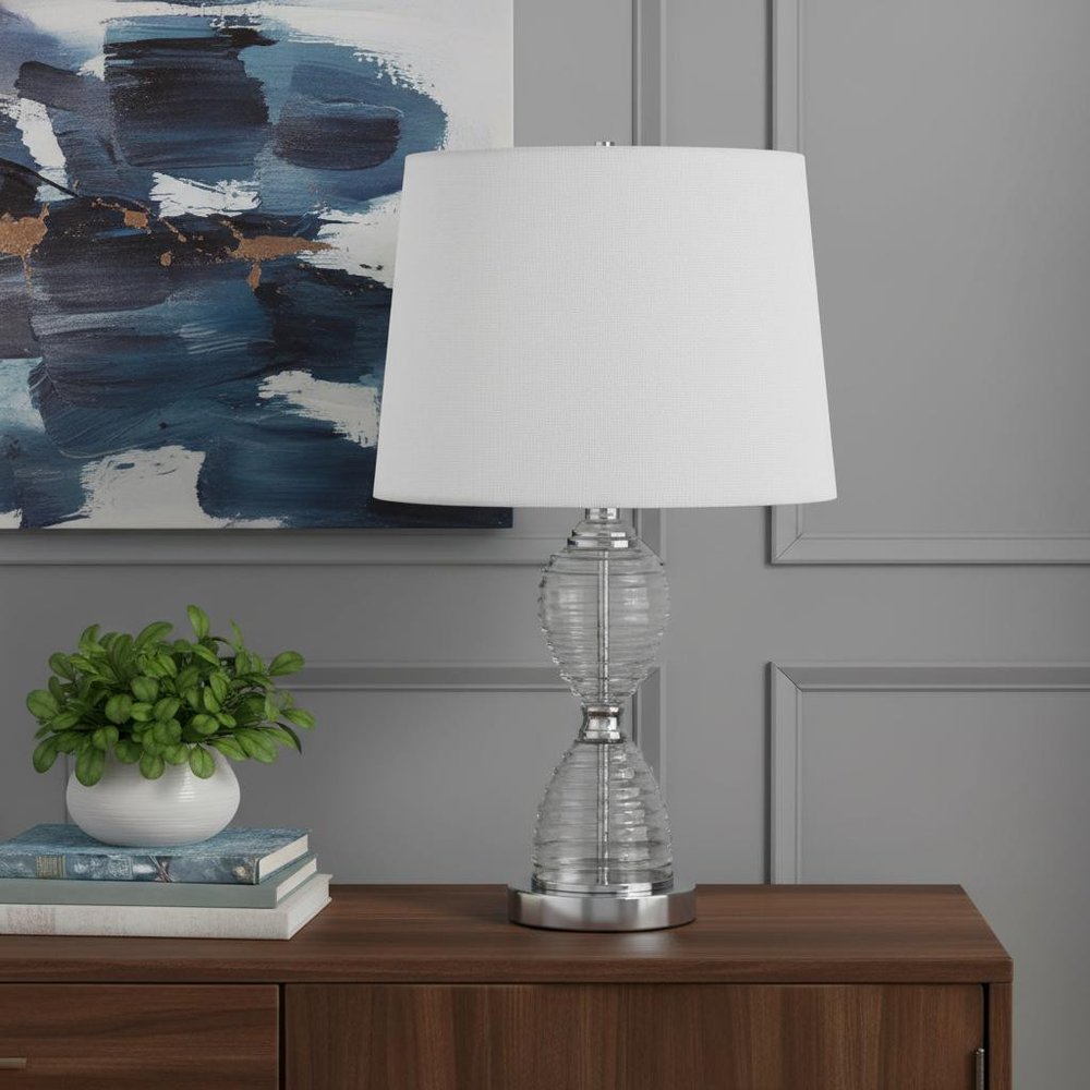 24" Clear Metal Table Lamp With White Empire Shade shown outdoors on an outdoor setting.