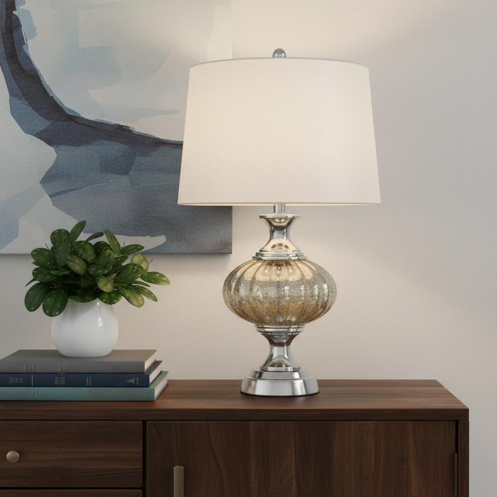27" Silver Metallic Metal Table Lamp With White Empire Shade displayed on a dark wood tabletop in a furnished interior against a cream wall.