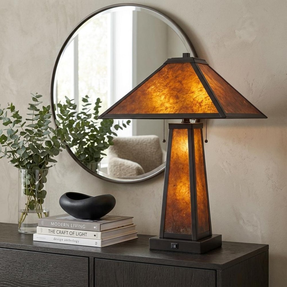 24" Burnt Orange Metal Two Light Table Lamp With Amber Square Shade displayed on a tabletop in a furnished interior against a tan wall.