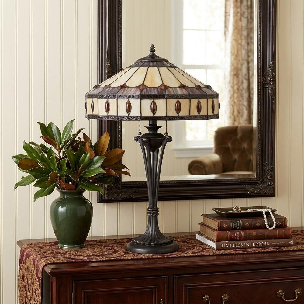 26" Black Metal Two Light Candlestick Table Lamp With Ivory and Red Dome Shade displayed on a tabletop in a furnished interior against a cream wall.