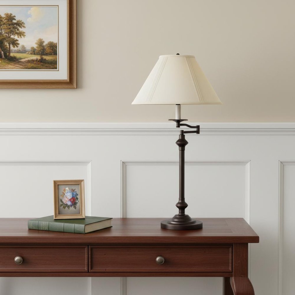 30" Antiqued Bronze Metal Swing Arm Table Lamp With Off White Empire Shade displayed on a tabletop in a furnished interior against a cream wall in off-white metal.