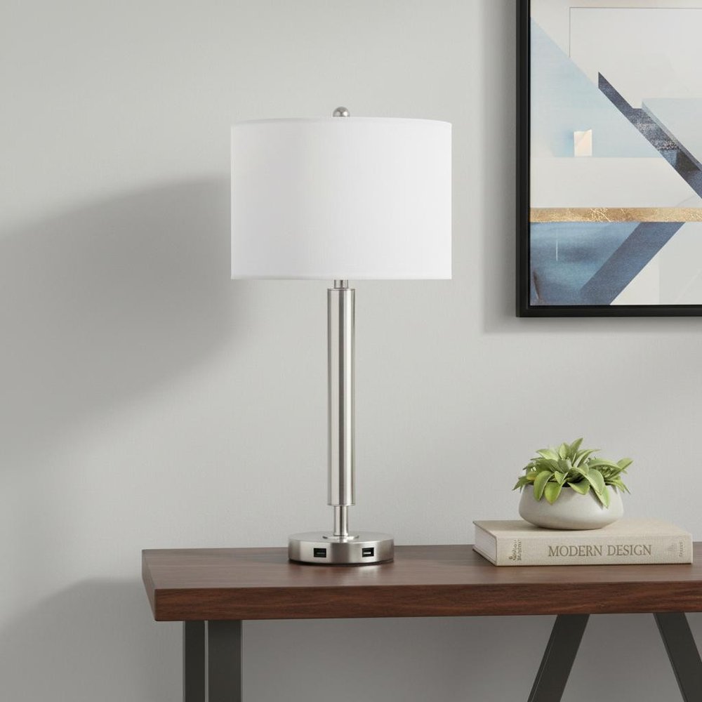 30" Nickel Metal Cylinder USB Table Lamp With White Drum Shade displayed on a tabletop in a furnished interior against a light gray wall in silver metal.