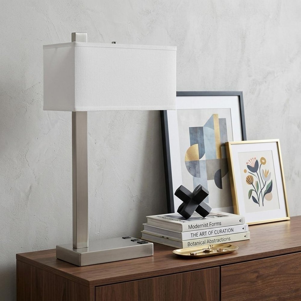 25" Nickel Metal Desk USB Table Lamp With White Shade displayed on a dark wood tabletop in a furnished interior against an off-white wall in silver metal.