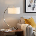 26" Nickel Metal Lantern Desk USB Table Lamp With White Shade displayed on a dark wood tabletop in a furnished interior against a light gray wall in silver metal.