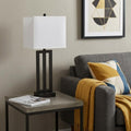 30" Black Metal USB Table Lamp With White Shade displayed on a dark wood tabletop in a furnished interior against a tan wall.