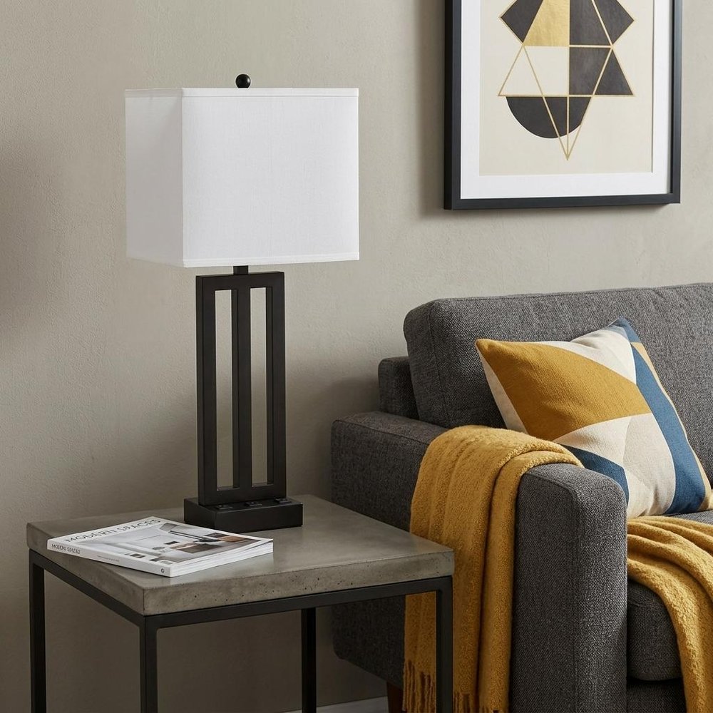 30" Black Metal USB Table Lamp With White Shade displayed on a dark wood tabletop in a furnished interior against a tan wall.