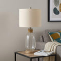 26" Brown Mason Jar Table Lamp With Brown Drum Shade displayed on a wood tabletop in a furnished interior against a light gray wall.
