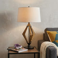 30" Black Metal Lantern Table Lamp With Gray Empire Shade displayed on a dark wood tabletop in a furnished interior against a light gray wall.