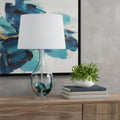 27" Clear Glass Table Lamp With White Empire Shade shown outdoors on an outdoor setting.