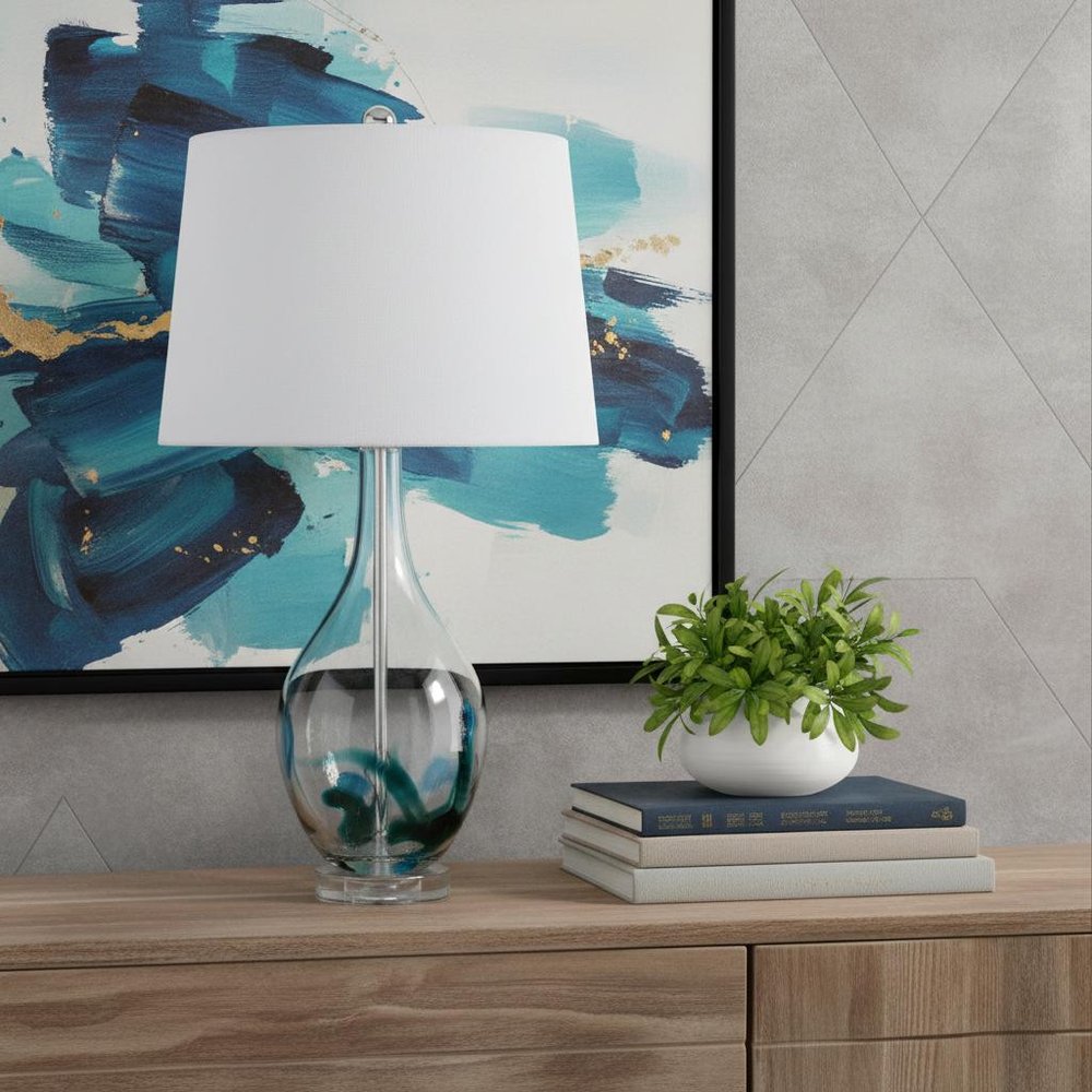 27" Clear Glass Table Lamp With White Empire Shade shown outdoors on an outdoor setting.