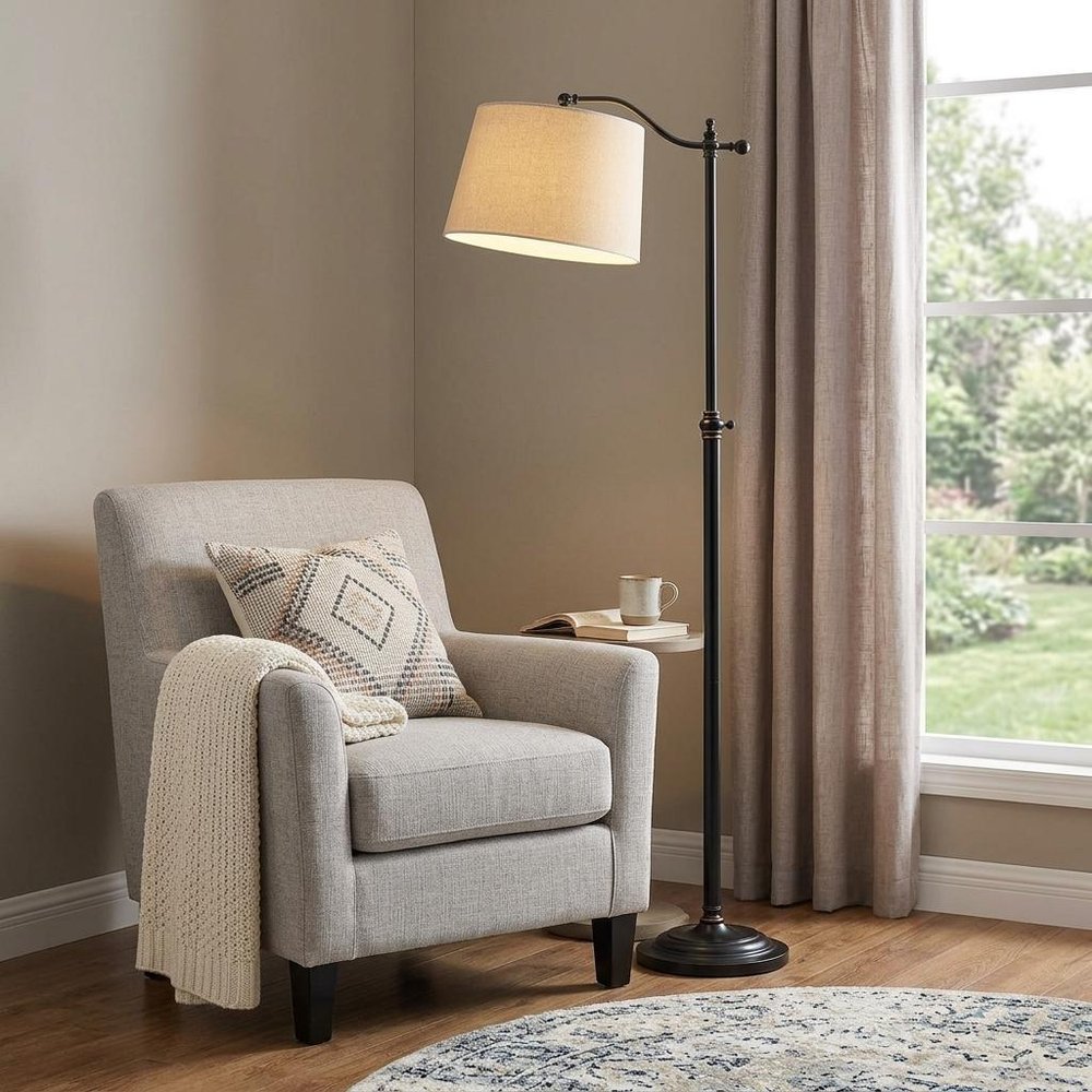 63" Bronze Metal Adjustable Floor Lamp With Tan Paper Square Shade standing in a furnished interior on a dark wood floor.