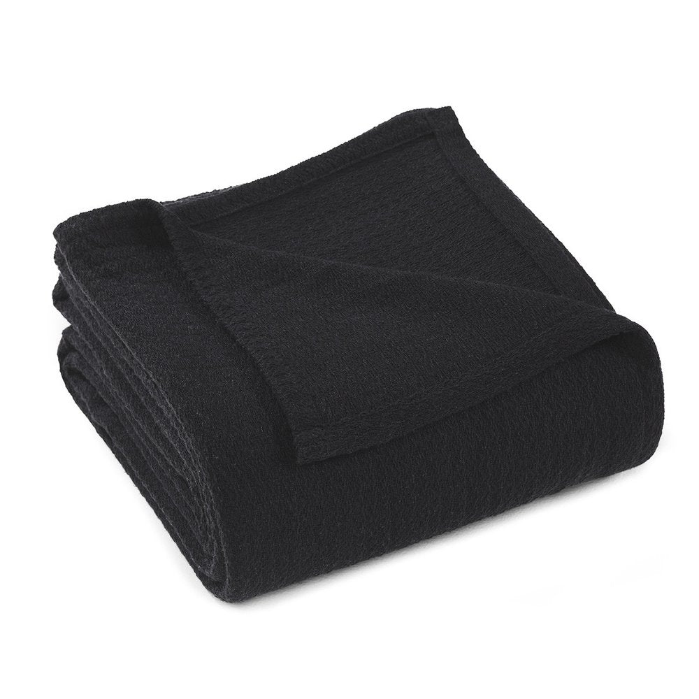 Black cotton waffle weave blanket folded on a white background.