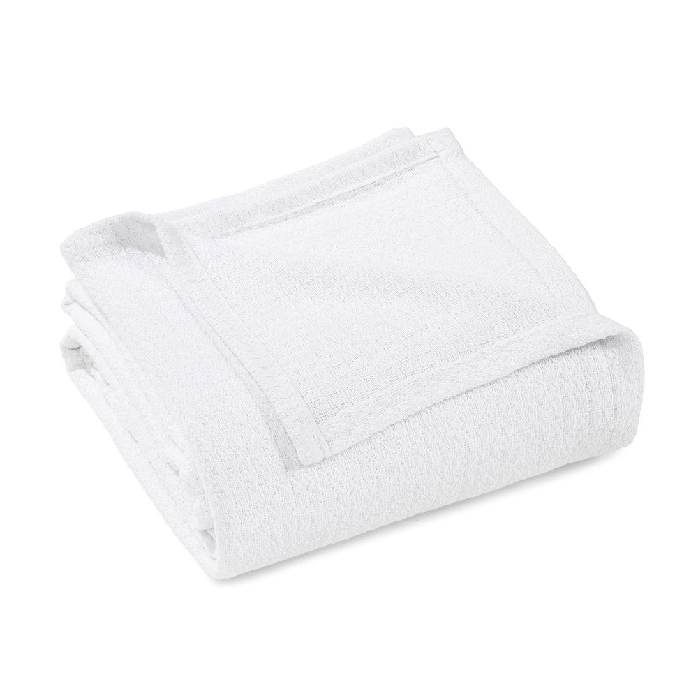White cotton waffle weave blanket folded on a white background