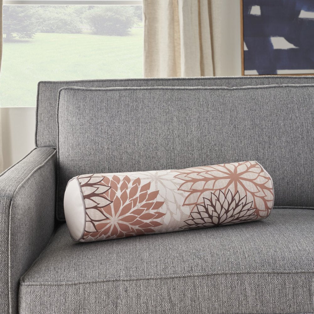 6" X 20" Brown Beige and Ivory Bolster Floral Indoor Outdoor Throw Pillow styled in a furnished interior with an off-white wall on a tiled floor.