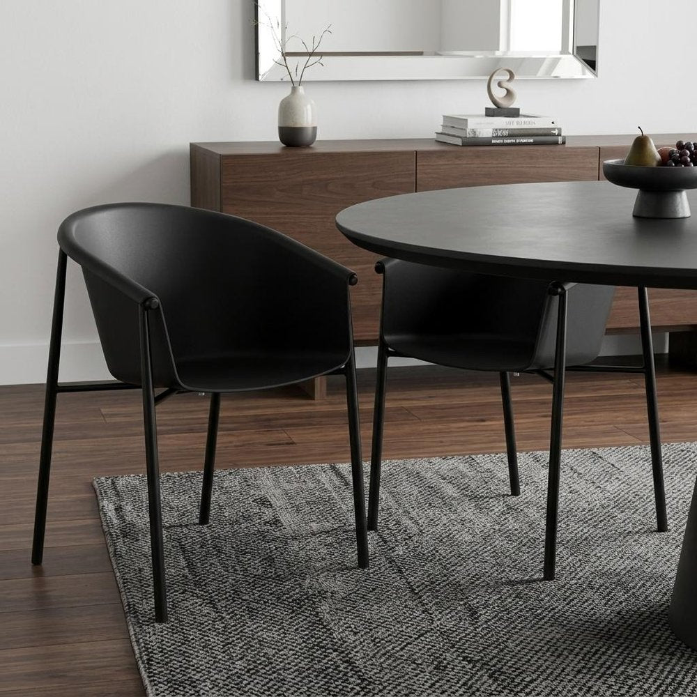 Set of Two Black Heavy Duty Plastic Outdoor Stacking Dining Chairs - 31.50" H x 23.00" W x 23.00" D in a home interior