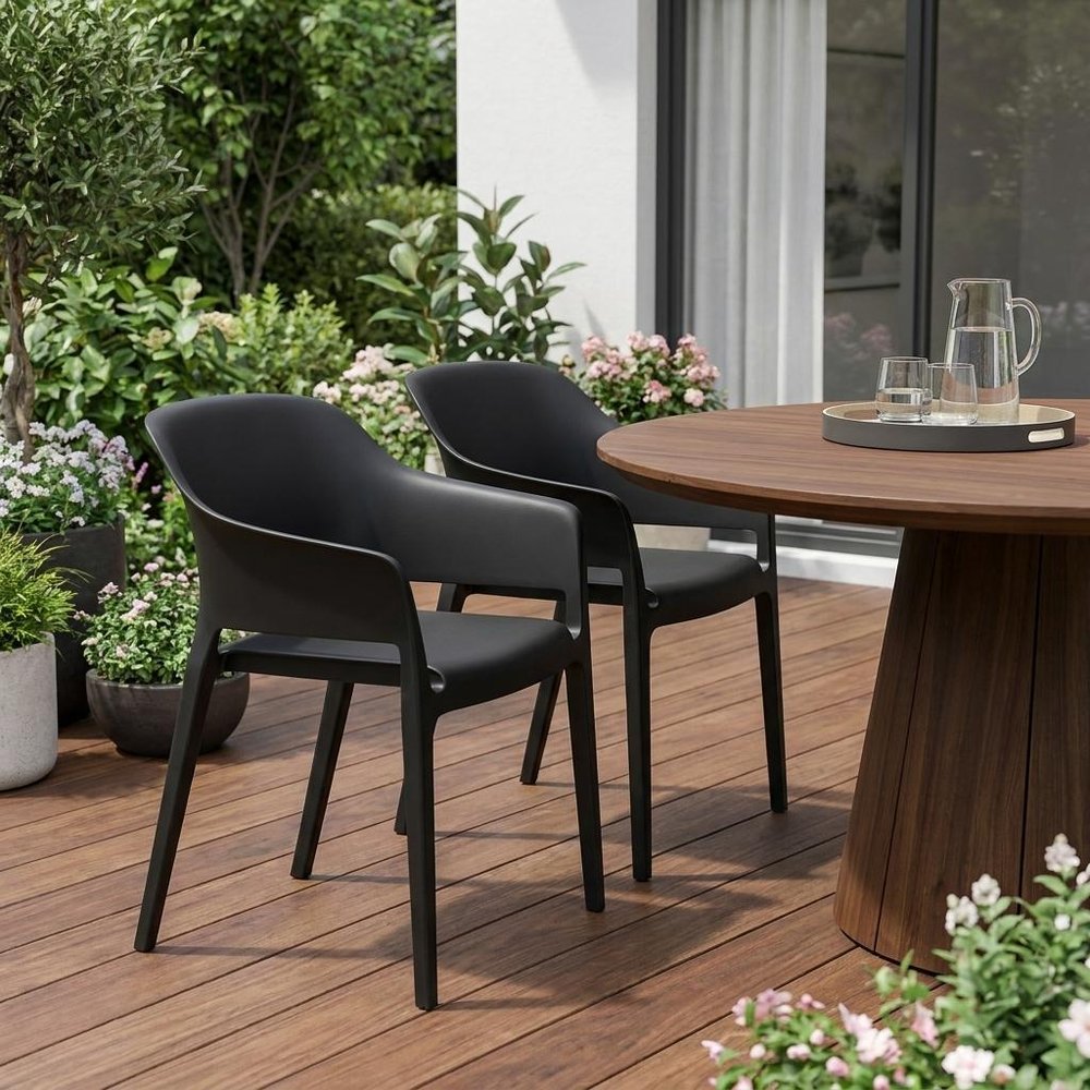 Set of Two Black Heavy Duty Plastic Outdoor Stacking Dining Chairs - 30.50" H x 21.50" W x 21.60" D in a home interior