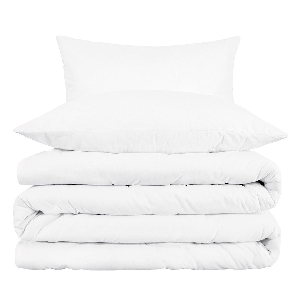 Stack of white bedding including a pillow and folded duvet covers on a white background.