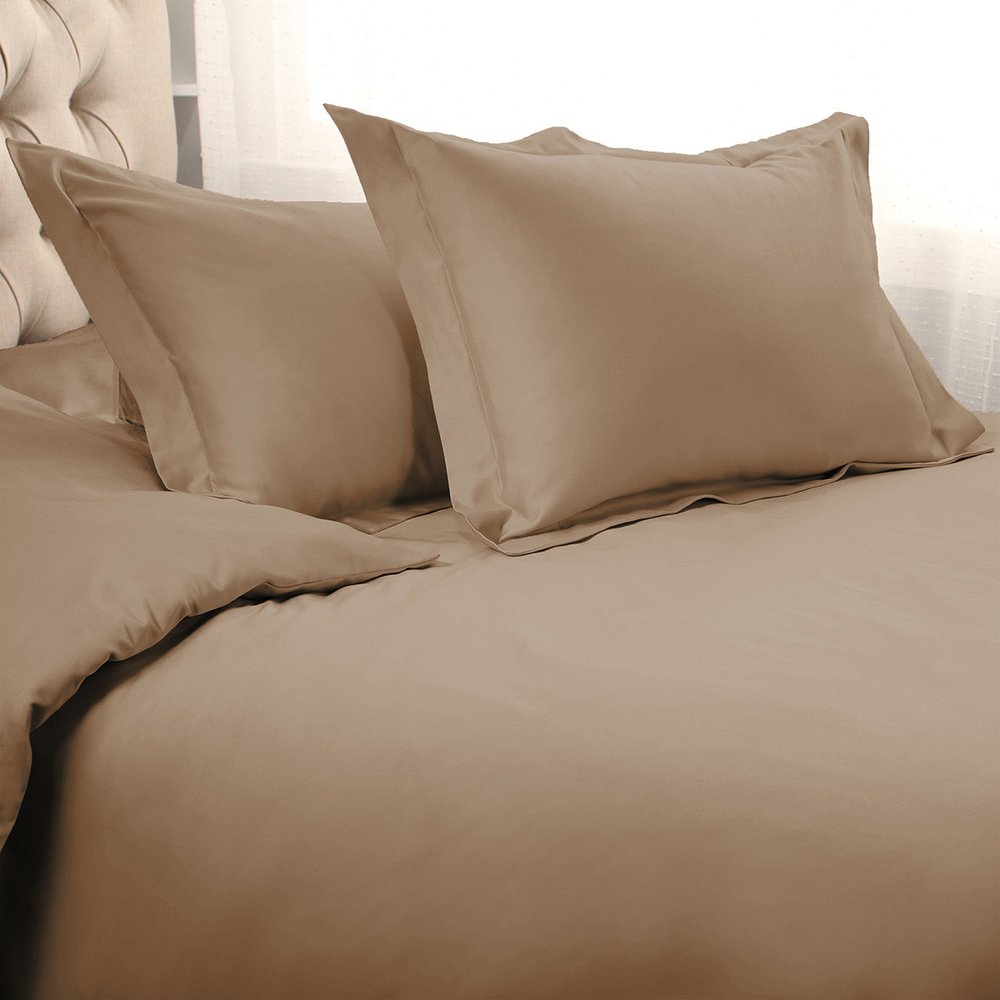 Taupe queen cotton duvet cover set with two pillows on a tufted headboard and sheer curtains in the background.