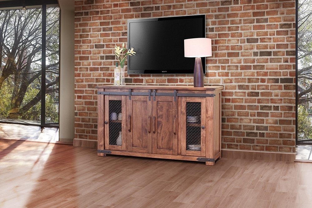 60" Brown Solid Wood Cabinet Enclosed Storage Distressed TV Stand styled in a furnished interior with a dark brown wall on a wood floor.