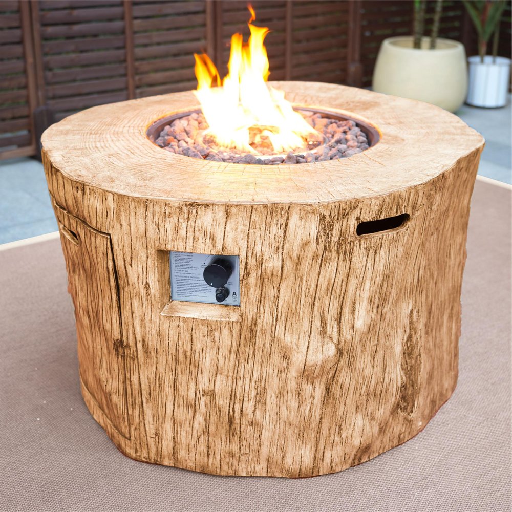 37" Brown Faux Wood Stump Propane Round Fire pit With Cover styled in a furnished interior with a dark brown wall on a blush floor.