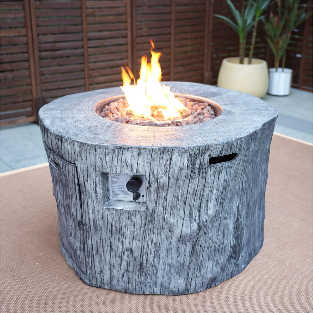 50000 BTU 40" Gray Aluminum Natural Gas Round Fire Pit Table With Cover styled in a furnished interior with a burgundy wall on a blush floor.