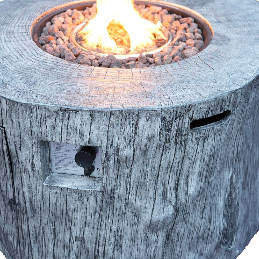 50000 BTU 40" Gray Aluminum Natural Gas Round Fire Pit Table With Cover shown outdoors on a patio in tan metal.