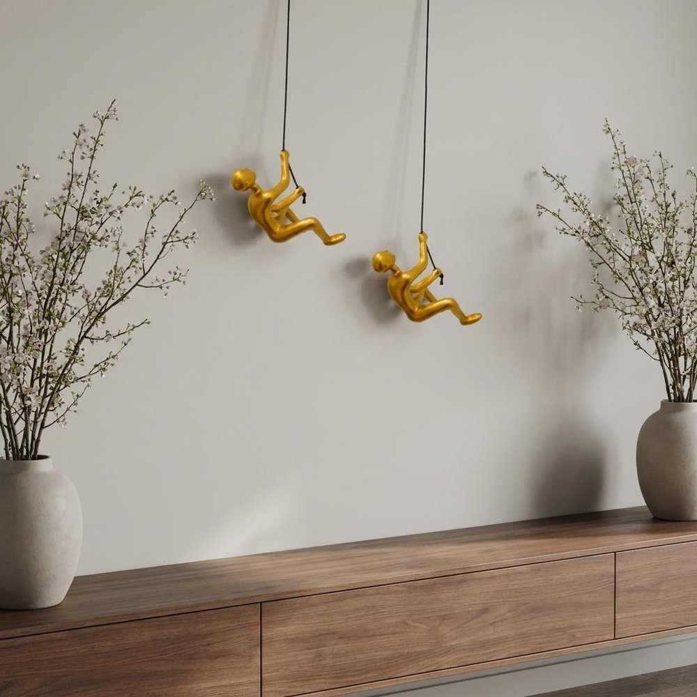 Set of Two Gold Resin Climbing Man Hanging Dimensional Sculpture in a home interior