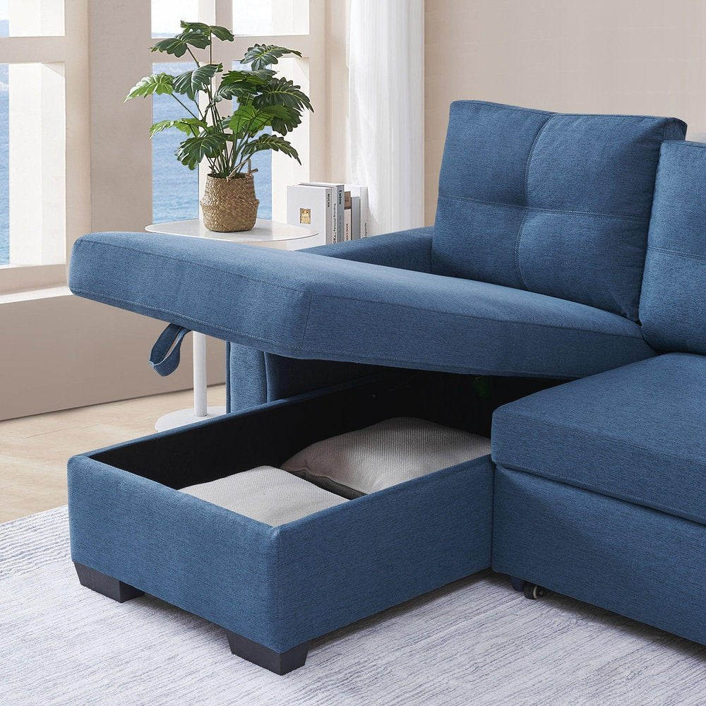 Blue polyester blend convertible futon sleeper sofa with open storage compartment revealing pillows, in a bright room with a window view.