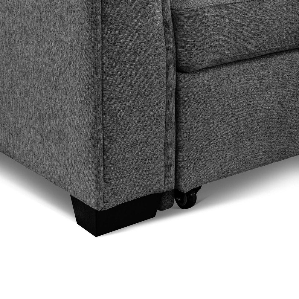 Close-up of a dark gray polyester blend futon sofa with black legs and wheels on a white background.