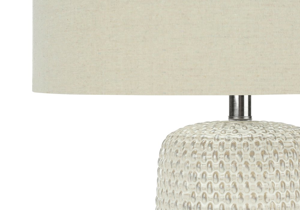 31" Cream Ceramic Geometric Table Lamp With Beige Drum Shade. Table lamp in cream ceramic.